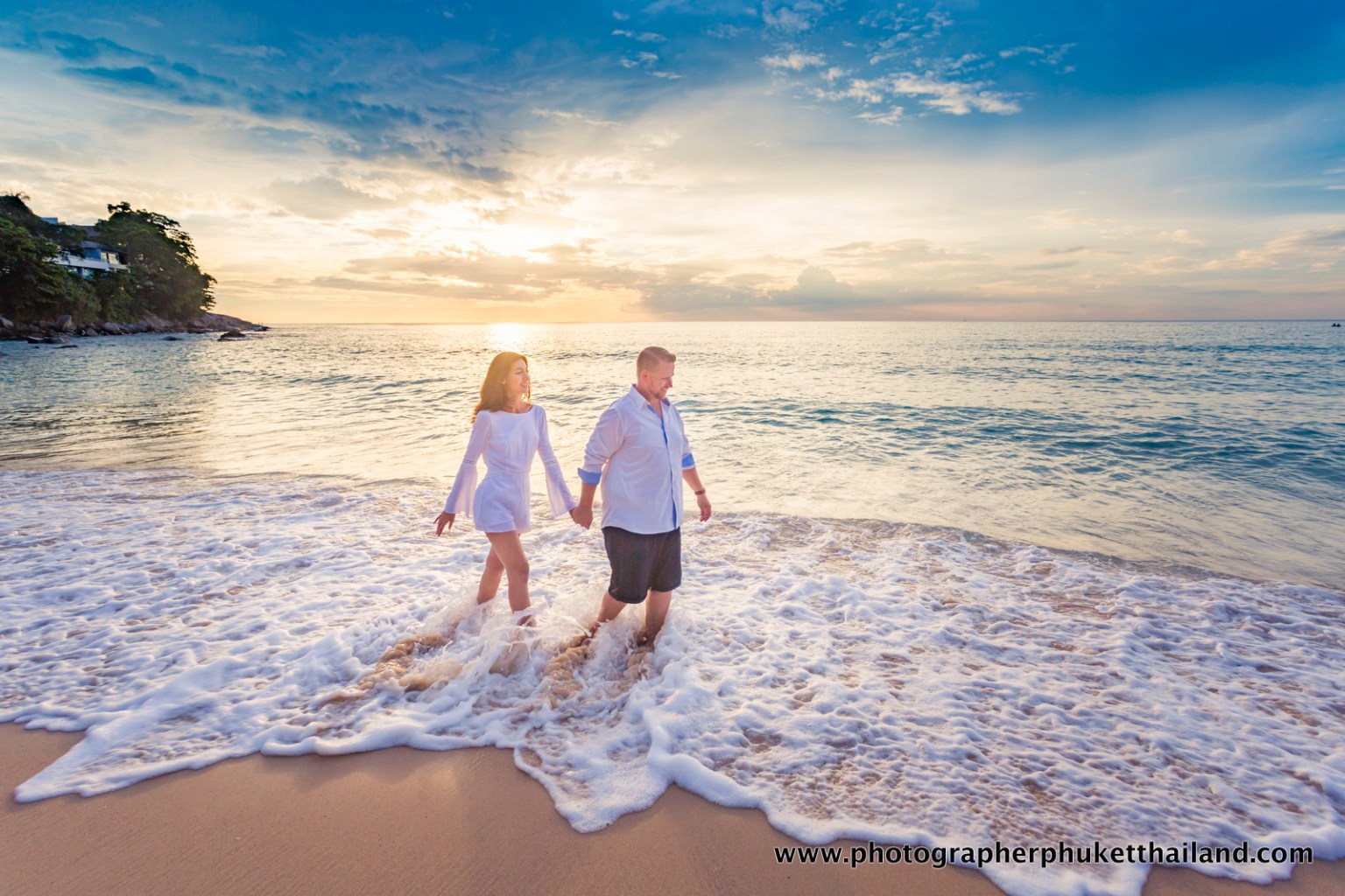 A couple walking hand in hand along a beach, with the sun setting over the ocean, creating a serene and romantic atmosphere.