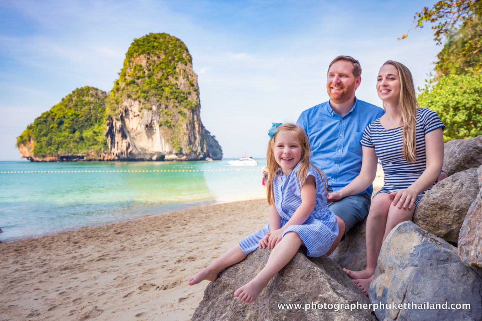 Family portrait on the beach in Krabi, Thailand, with limestone cliffs in the background.